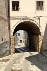 Fototapeta premium Ancient stone archway leading to cobblestone alley, Cividale del Friuli, Italy