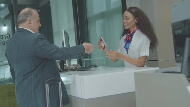 caucasian businessman handing passport to airline staff at check in counter. passenger received the ticket that issued from the female staff in airport terminal. Security Checkpoint in International.