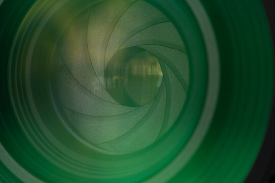 Close-up of Professional Camera Lens Aperture with Green Optical Coating,Detailed macro shot of a camera lens diaphragm blades and aperture opening, featuring vibrant green multi-coating reflections.
