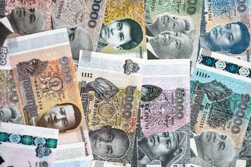 Cambodian riel money bills pile on table. Cambodia banknotes of KHR currency close up. Concept of business, economy and banking in Cambodia © mehaniq41
