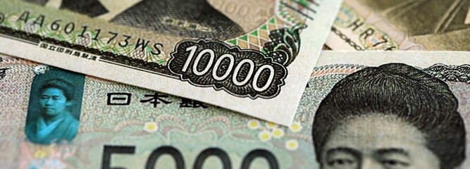 Japanese yen money bills pile on table. Japan banknotes of JPY currency close up. Concept of business, economy and banking in Japan © mehaniq41