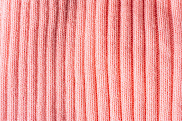Fototapeta premium Pink ribbed knit texture background, knitted fabric surface close up.