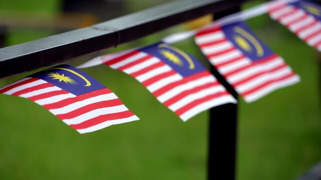 Slow motion Malaysian flags hanging side by side on a rail