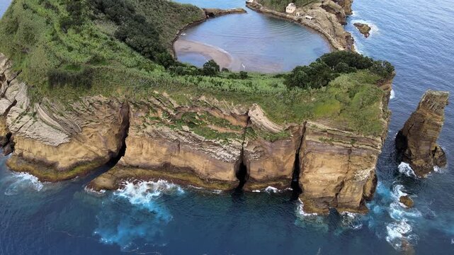 Cinematic aerial drone view of the volcanic islet of Vila Franca do Campo near S&atilde;o Miguel Island in the Azores, Portugal. The ring-shaped crater forms a natural lagoon surrounded by dramatic cliffs an