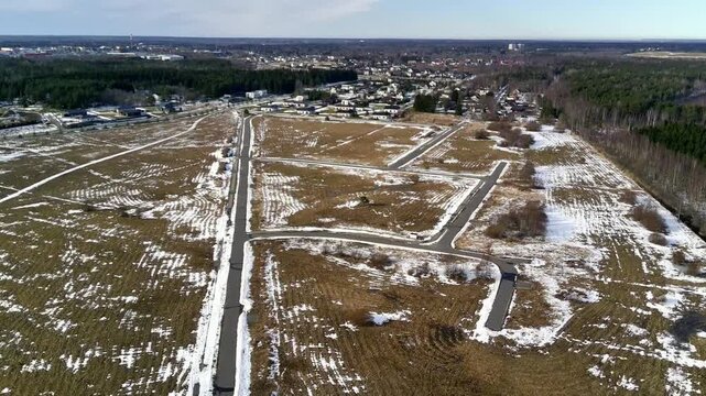 Drone flying above new residential development area with empty plots