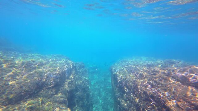 Sunlight refracting through clear turquoise water onto a rocky volcanic reef on Pr&iacute;ncipe Island, S&atilde;o Tom&eacute; and Pr&iacute;ncipe.