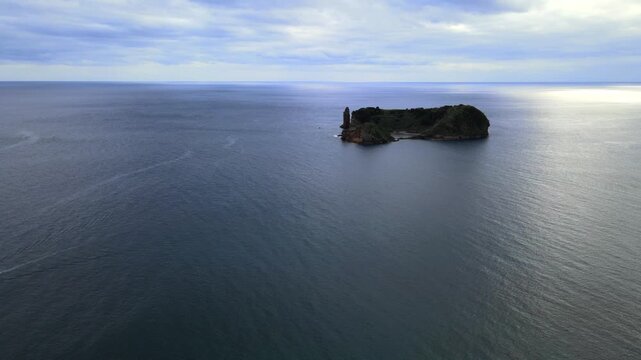 Cinematic aerial drone view of the volcanic islet of Vila Franca do Campo near S&atilde;o Miguel Island in the Azores, Portugal. The ring-shaped crater forms a natural lagoon surrounded by dramatic cliffs an
