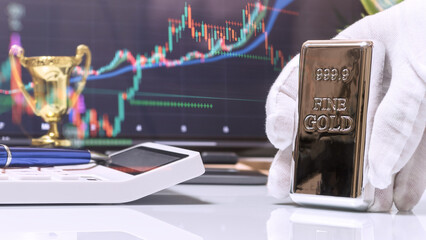 Gloved Hand Presenting Gold Bar with Trophy and Market Screen