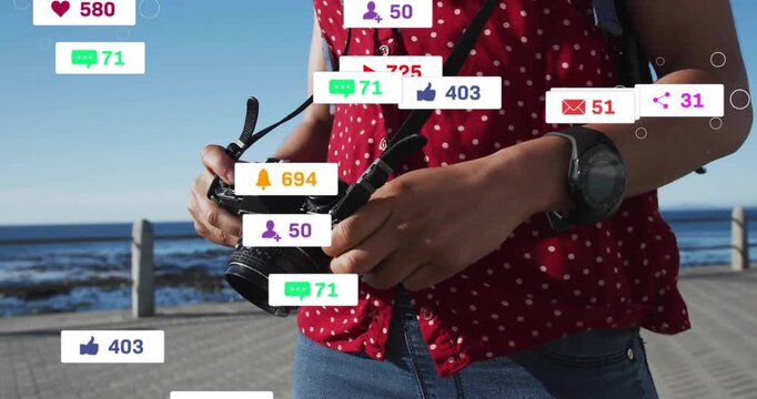 Female photographer strapping camera, adjusting dial while social icons multiplying, growing reach