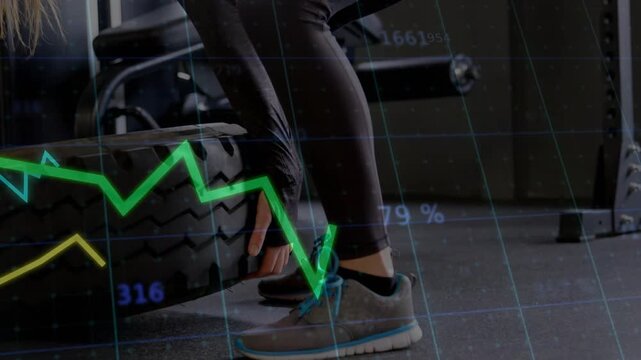 Gym trainee gripping tire tread lifting driving hips to flip tire as animated graphs tracking data