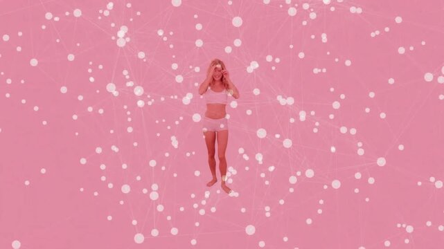 Model balancing to steps and fixing hair on pink set while white bokeh obscuring, modeling fashion