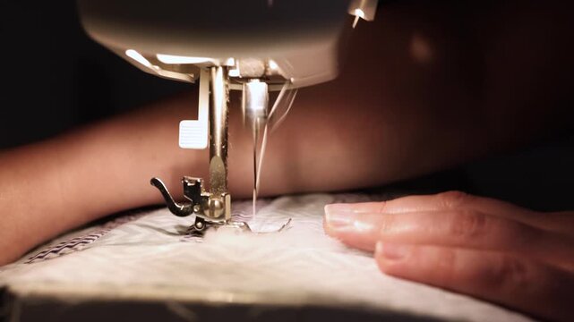 Sewing machine stitching layered patchwork fabric with batting macro view