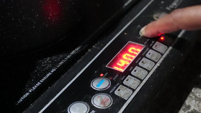 Women use induction cookers by placing compatible magnetic cookware on the cooking zone