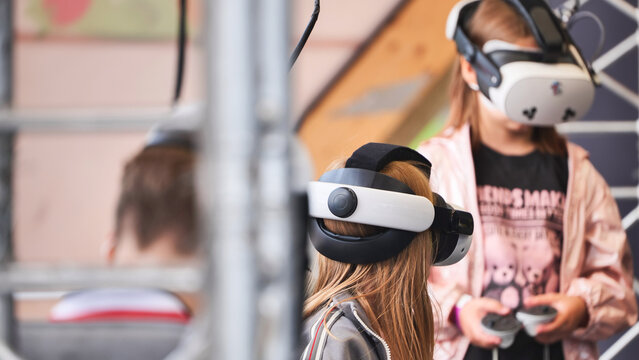 Girls experiencing virtual reality entertainment with VR headsets