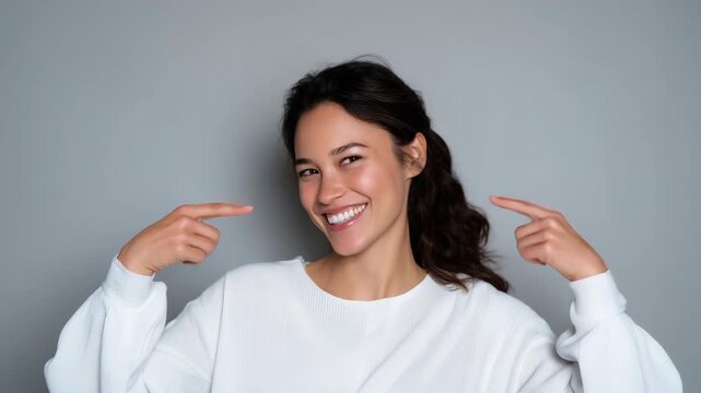 smiling woman pointing at herself, self confidence concept, cheerful female portrait, positive emotion, white sweater, studio background, happy expression, self esteem, body language