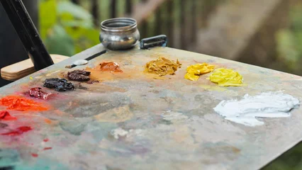 Fotobehang Schilderij Oil paint tubes laying on an artist's palette creating a colorful composition  © Довидович Михаил