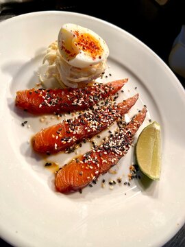 Fresh salmon sashimi topped with Japanese furikake seasoning, served with a creamy dipping sauce and lemon wedge. An elegant Japanese-inspired seafood dish perfect for restaurant, food and culinary co