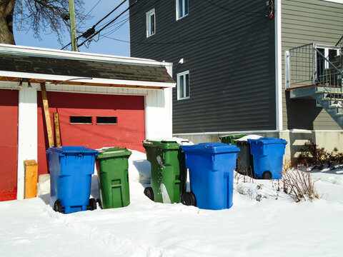 Poubelles dans la rue en hiver. Poubelle devant une maison enneig&eacute;e en hiver. Poubelles devant une maison en hiver au Qu&eacute;bec, Canada.