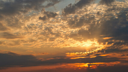 Obraz premium Dramatic sunset sky with jagged clouds glowing in blue and golden tones.