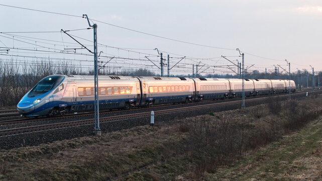 A fast intercity train runs on tracks in Poland.