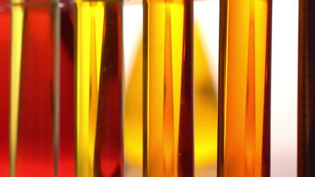 Reagenzgl&auml;ser und Mensuren mit bunten Fl&uuml;ssigkeiten drehen sich im Labor