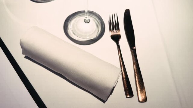 Close-up of a restaurant serving table with napkin, cutlery and glasses. High quality 4k footage