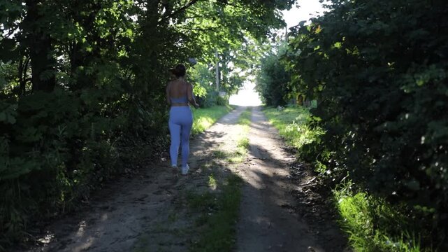 a young woman jogging in the countryside in summer