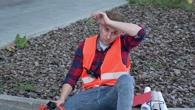 Tired construction worker resting after work on development site