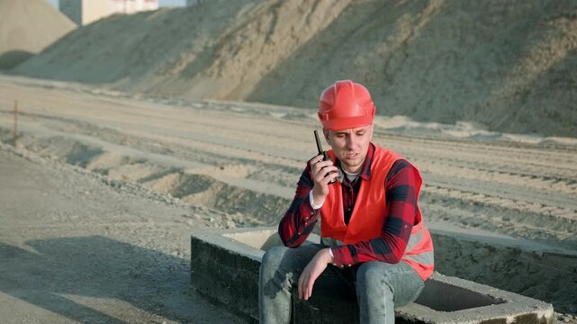 Foreman holding walkie-talkie and gives instructions on site