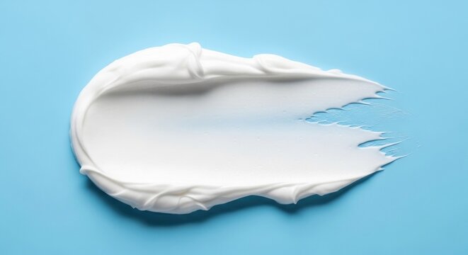 A smear of white cream on a light blue background with uneven edges