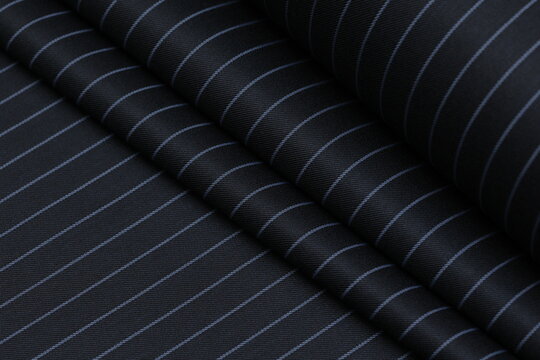 Premium navy blue pinstripe suiting fabric with a professional wool-blend texture. High-quality textile featuring classic thin stripes and elegant draping for luxury tailoring. Perfect business attire