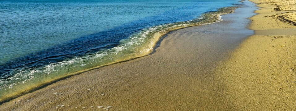 Clear turquoise Mediterranean water forming a small wave on sandy shoreline at Pampelonne Beach. Ramatuelle, France &ndash; August 30, 2025
