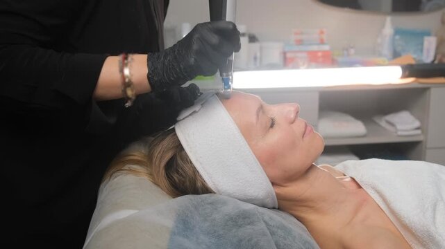 Cosmetologist performing professional microneedling therapy on a client's face at a beauty spa