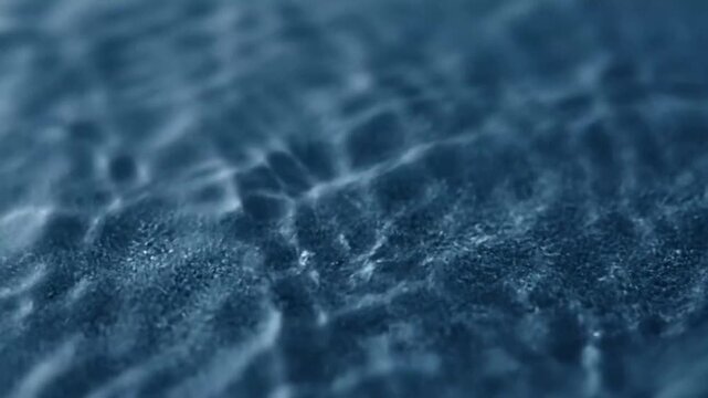 Blue granular surface with water ripple and soft focus