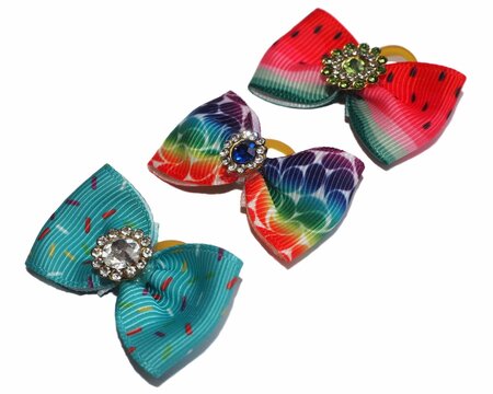 Colorful handmade dog hair bows with rhinestone centers, featuring watermelon, rainbow, and sprinkle patterns. Isolated on white background, stylish pet grooming accessories.