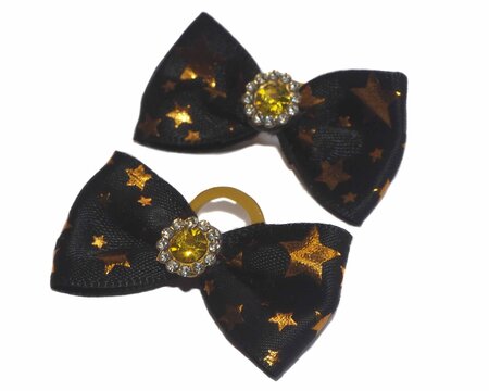 Two handmade dog grooming bows made of black satin fabric with gold stars and crystals on a white background. A fashionable accessory for small breed pets.