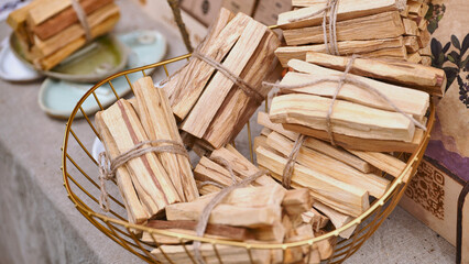 Obraz premium Palo santo wood bundles filling a golden basket at India Day in Moscow