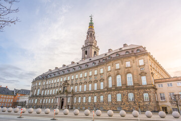 Obraz premium Visitors walk around Christiansborg Palace in Copenhagen, Denmark. The palace serves as a government building and is located on the Slotsholmen islet. Many people admire the historic architecture.