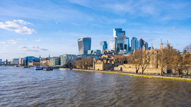 View of London skyline featuring the iconic Tower and modern skyscrapers along the River Thames. The scene captures the beauty of the city against a clear blue sky.