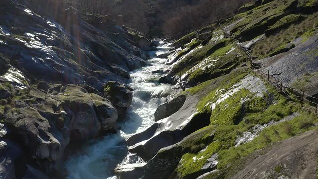 Aerial view of Los Pilones Bridge area in Garganta de los Infiernos, Spain. Exceptional river flow surging through granite formations in Jerte Valley, creating powerful whitewater and dramatic flood.