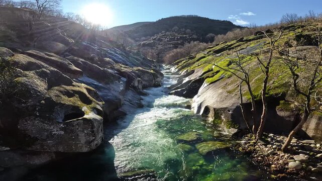 View of Los Pilones Bridge area in Garganta de los Infiernos, Spain. Exceptional river flow surging through granite formations in Jerte Valley, creating powerful whitewater and dramatic flood-l