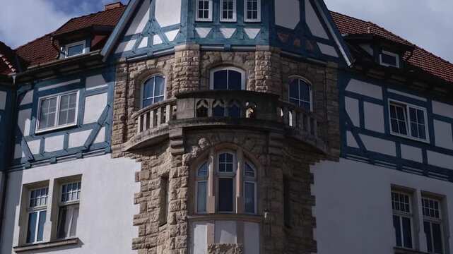 Half-timbered house with amazing blue timber frame in Meiningen, Thuringia - East Germany. Close-up slow motion of a traditional German building with balcony and beautiful facade. Tilt-up street view.