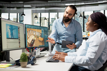 Fototapeta premium Team of diverse architectural specialists working with CAD program on computer, modern apartment layout with floor plan. 3D rendering software on dual monitors, interior design.