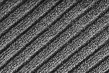 Close up, macro of gray colored knitted fabric with diagonal relief ribbed pattern and soft wool texture. Detailed textile surface, knitwear background, fashion, backdrop, design element. © katyamaximenko
