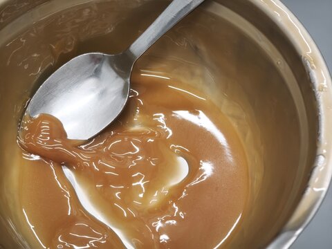 Plate with a spoon spread with Dulce de leche