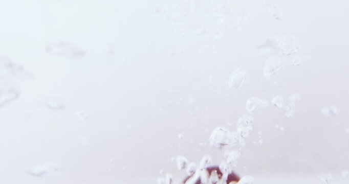 Ripe cherries splash into water, surrounded by air bubbles, Fresh, nutritious and ready for washing before eating