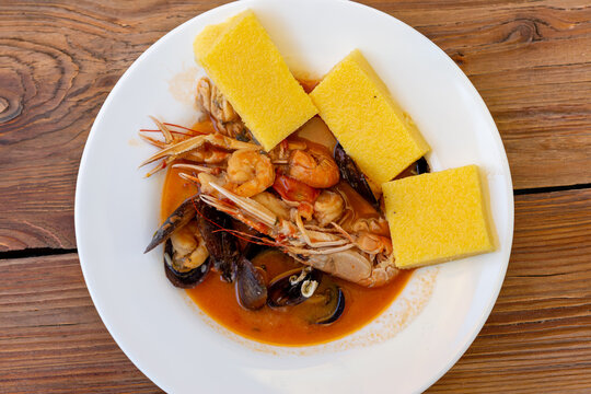 Scampi busara polenta Istrian dish Croatian seafood langoustine tomato sauce traditional Istria Adriatic Mediterranean regional cuisine