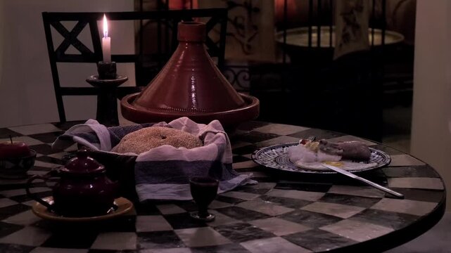 Traditional Moroccan table setting, featuring Terracotta tagine, bread, cakes, and tea, candle burning, cultural dining experience, Moroccan ceramic plates with traditional Moroccan patterns