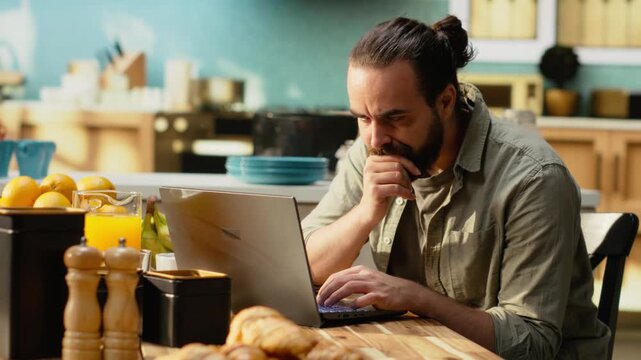 Confused disoriented man being uncertain about task completion, frowning at laptop screen while he works from home. Ambiguous misunderstanding information and person in doubt.
