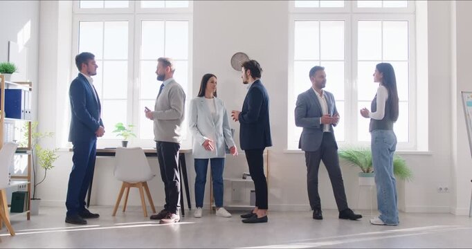 Business team meeting during corporate training. Professionals network in small groups in a bright office, exchanging ideas and aligning strategy. Group collaboration and planning concept.